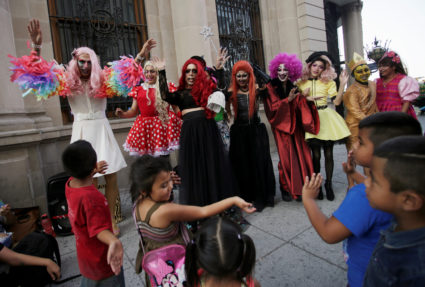 Participants dressed in drag dance along with children during the "Drag Queen Story Hour" event, which according to organi...