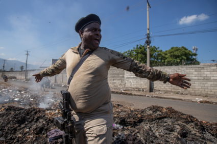 Former police officer Jimmy "Barbecue" Cherizier, leader of the 'G9' coalition, stands on a pile of garbage as he speaks of living conditions in the La Saline shanty area of Port-au-Prince, Haiti November 3, 2021. Photo by Ralph Tedy Erol/REUTERS