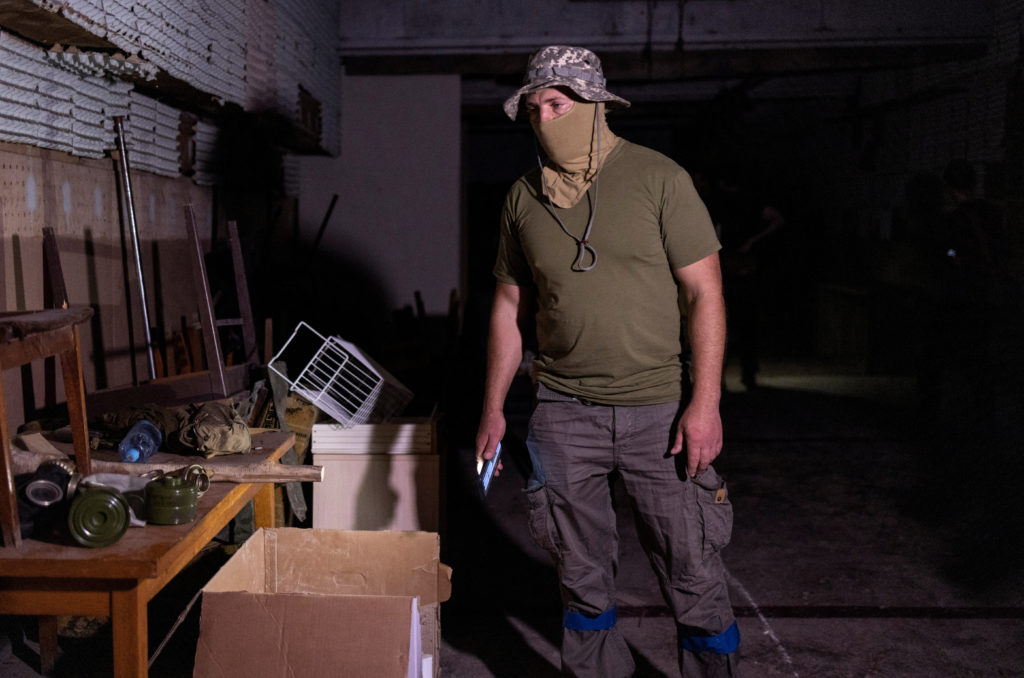 A Ukrainian serviceman stands at a room in a police station which he says was used as a torture chamber by Russian soldier...