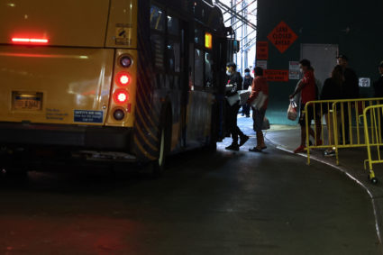 Migrants transported from the U.S. border board a bus waiting for relocation after arriving at the Port Authority bus term...