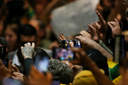 Brazil's President and candidate for re-election Jair Bolsonaro is seen on a phone screen as he attends the National Sweet Fair (Fenadoce) in Pelotas, State of Rio Grande do Sul, Brazil, October 11, 2022. Photo by Diego Vara/REUTERS