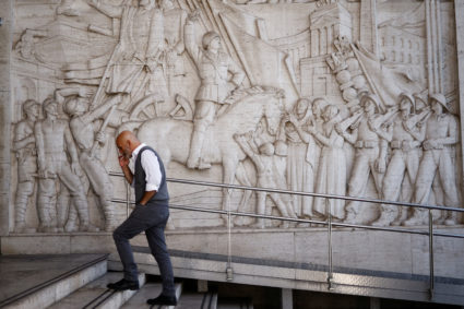A man walks past a bas-relief depicting fascist leader Benito Mussolini at the EUR neighbourhood known for its fascist architecture in Rome, Italy, October 19, 2022. Photo by Guglielmo Mangiapane/REUTERS