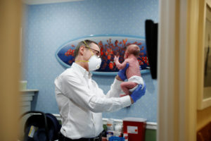 Dr Greg Gulbransen performs a checkup on a young baby as her mother watches while maintaining visits with both his regular...