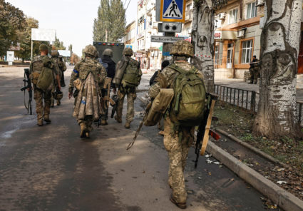 Ukrainian soldiers walk in Bakhmut