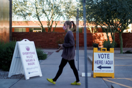 FILE PHOTO: A woman walks to cast her ballot at the register of voters during early voting in Phoenix, Arizona