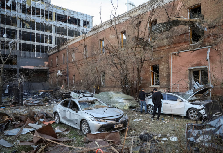 Local residents check their car, destroyed by the previous day's Russian military strike, as Russia's attack on Ukraine co...