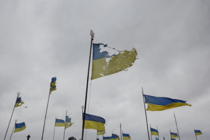 National flags wave over graves of Ukrainian soldiers killed during Joint Forces Operation in the country's eastern regions are seen damaged, as local orthodox priest says, by a shell of Russian tank, as Russia's attack on Ukraine continues, at a cemetery in Chernihiv, Ukraine April 6, 2022. Photo by Serhii Nuzhnenko/REUTERS