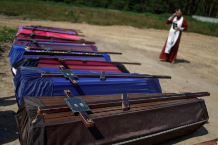 Orthodox priest Andrii Halavin conducts a burial service for unidentified people killed by Russian troops during a mass burial ceremony, amid Russia's attack on Ukraine, in the town of Bucha, in Kyiv region, Ukraine August 17, 2022. Photo by Valentyn Ogirenko/REUTERS