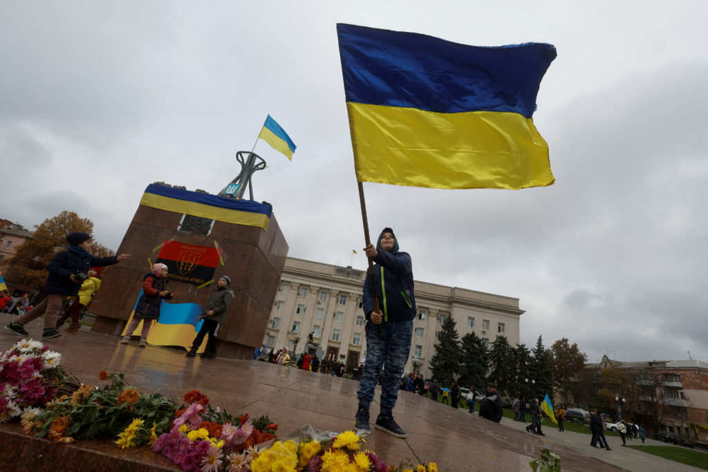 Boy waves a national flag as he celebrates after Russia's retreat from Kherson, in central Kherson