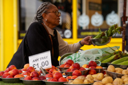 FILE PHOTO: A woman shops for food items at a market stall in London