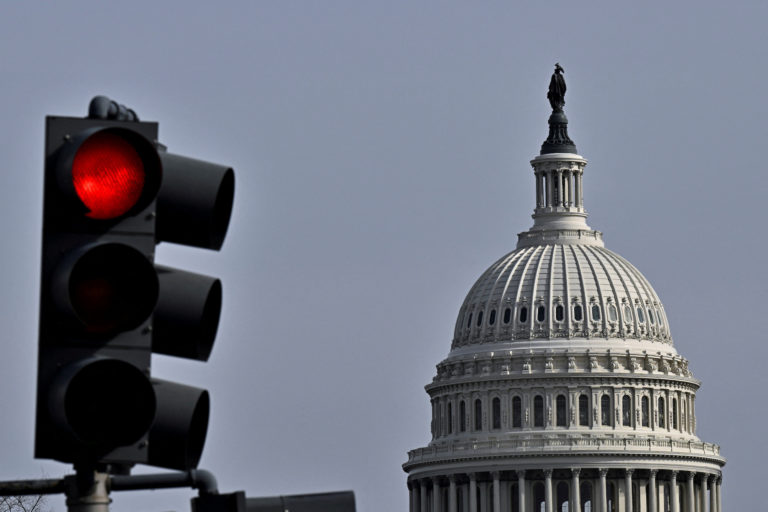 FILE PHOTO: Red light traffic signal is seen with the dome of the U.S. Capitol building in the distance, in Washington