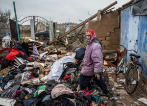 Lidiia, 60, a local resident, looks for her things in her destroyed house in the village of Pokrovskii Posad