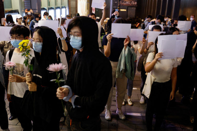People hold white sheets of paper in protest over COVID-19 restrictions in mainland China, in Hong Kong