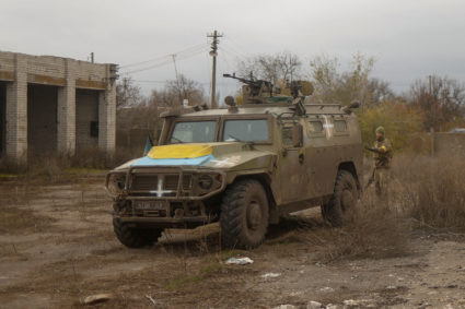 Ukrainian service member stands next to a previously captured Russian armoured personnel carrier in the village of Blahoda...