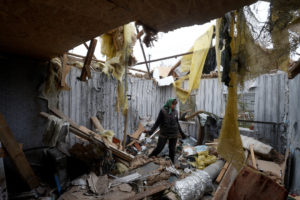 Local resident Serhii Tamara removes debris inside a house of her son, destroyed during a Russian military attack in the v...