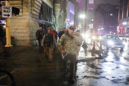 Stewart Rhodes of the Oath Keepers holds a radio departs a Trump rally in Minneapolis