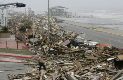A man walks amid debris from Hurricane Ike that was cleared from the road in Galveston
