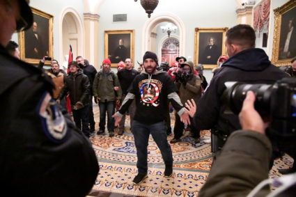 Douglas Austen Jensen of Iowa, a supporter of President Donald Trump wearing a QAnon shirt, confronts police as Trump supporters demonstrate on the second floor of the U.S. Capitol near the entrance to the Senate after breaching security defenses, in Washington, U.S., January 6, 2021. Photo by Mike Theiler/REUTERS