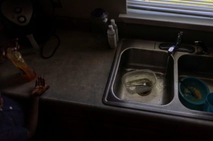 Water is seen running from a faucet as a kid prepares to wash his hands while the city of Jackson is to go without reliable drinking water indefinitely after pumps at the water treatment plant failed, leading to the emergency distribution of bottled water and tanker trucks for 180,000 people, in Jackson, Mississippi, U.S., September 1, 2022. Photo by Carlos Barria/REUTERS