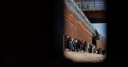 Asylum-seeking migrants wait at the border between Mexico and the U.S.,