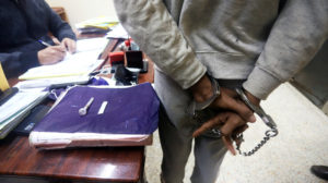 An Iraqi suspect who was arrested for drug-related crimes is seen handcuffed at a police station in Basra