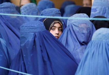 A girl looks on among Afghan women lining up to receive relief assistance, during the holy month of Ramadan in Jalalabad, Afghanistan, June 11, 2017. Photo by Parwiz/REUTERS