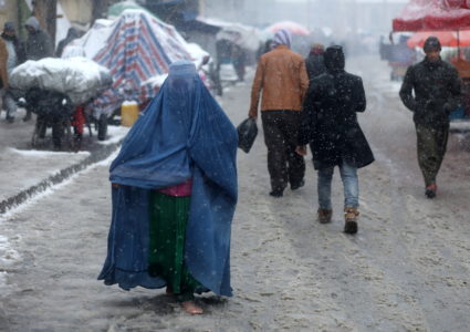 An Afghan woman walks on the street during a snowfall in Kabul, Afghanistan, January 3, 2022. Photo by Ali Khara/REUTERS