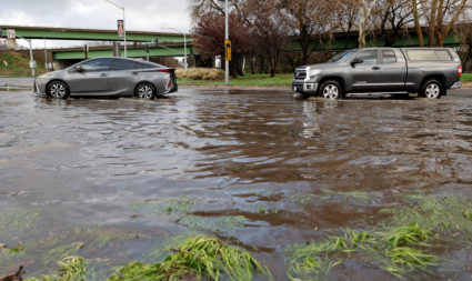 Drivers navigate a flooded street after winter storms brought high winds and heavy rain in Sacramento