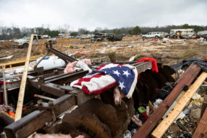 A flag is draped on the remnants of a home destroyed by a tornado in Old Kingston