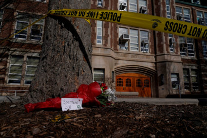 A bouquet rests by police tape surrounding Berkey Hall following a shooting on the Michigan State University campus