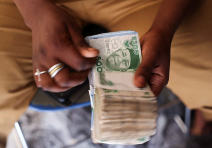 Man counts Nigerian naira notes in a market place ahead of Nigeria's Presidential elections in Yola