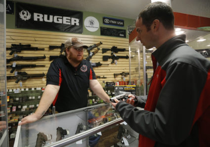 Metro Shooting Supplies' employee Chris Cox speaks to Steve Christy about the purchase of a 9mm handgun in Bridgeton