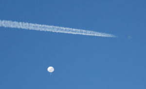 A jet flies by a suspected Chinese spy balloon as it floats off the coast in Surfside Beach