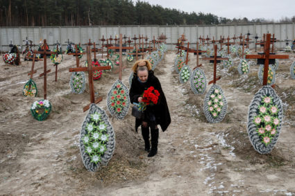 People visit graves of unidentified people, on a day of the first anniversary of Russia's attack on Ukraine, in Bucha
