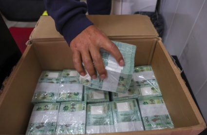 A money exchange vendor holds stacks of Lebanese pound banknotes at a shop in Beirut, Lebanon January 19, 2023. Photo by Mohamed Azakir/REUTERS
