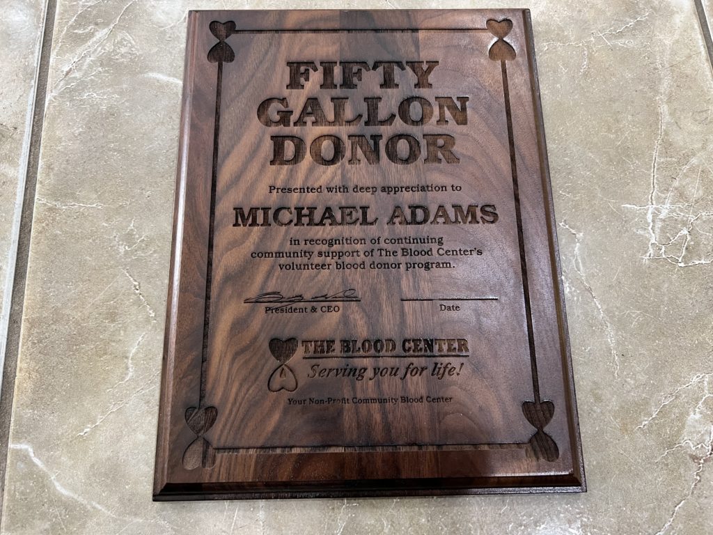 Plaques honoring a man for donating 50 gallons of blood. 