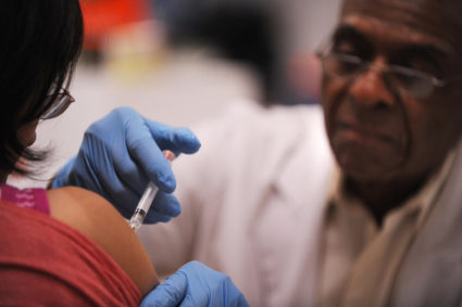 A registered nurse administers an immuni