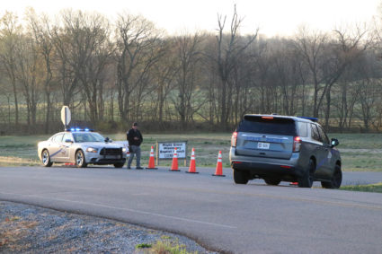 A security official stands near police cars at a site where two U.S. Army Black Hawk helicopters crashed in Kentucky