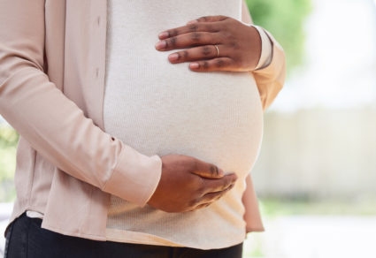Cropped shot of an unrecognizable mother to be standing in her living room at home