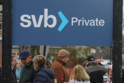 Customers wait in line outside a branch of Silicon Valley Bank in Wellesley