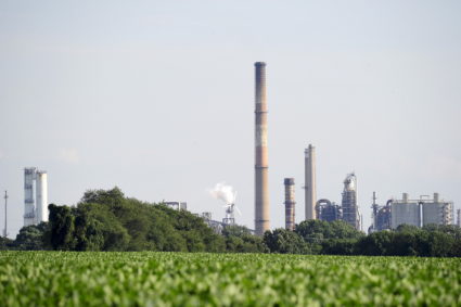 Smokestacks and cooling towers seen across a field of crops at the facility where a fire broke out at a key gasoline-makin...