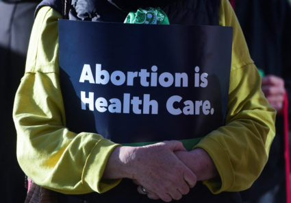 Kathy Thomas holds an “abortion is healthcare” sign during the Women's March protest outside of the Federal Courthouse against U.S. District Judge Matthew Kacsmaryk as he hears a motion by anti-abortion groups led by Alliance for Hippocratic Medicine to pull mifepristone, a drug used in medication abortion, off the market, in Amarillo, Texas, U.S., March 15, 2023. Photo by Annie Rice/REUTERS