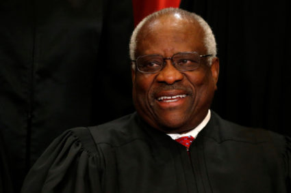 Thomas participates in taking a new family photo with fellow justices at the Supreme Court building in Washington