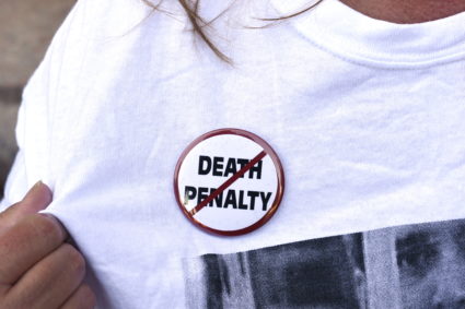 An anti-death penalty button is worn by a demonstrator attending a protest against the scheduled execution of convicted mu...