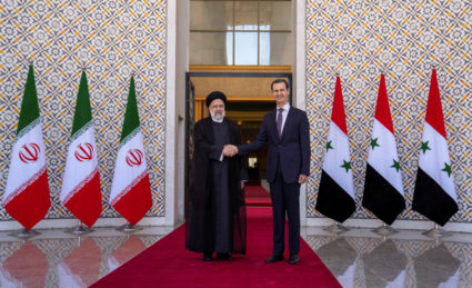 Syria's President Bashar al-Assad stands with Iranian President Ebrahim Raisi in Damascus
