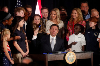 Florida Gov. Ron DeSantis holds up his pen while signing five state house bills into law after giving a press conference at Cambridge Christian School in Tampa, Florida, U.S. May 17, 2023. Photo by Octavio Jones/REUTERS