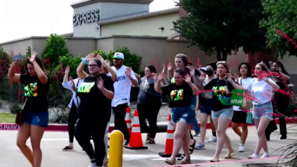 Shoppers leave with their hands up after police responded to a gunman at Allen Premium Outlets