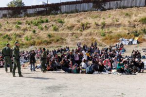 Migrants gather along the U.S. Mexico border near San Diego before the lifting of Tile 42