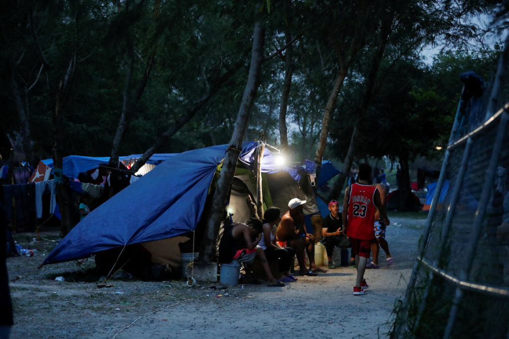 Migrants seeking asylum in the U.S. wait at an encampment as they try to get an appointment using the CBP ONE application,...