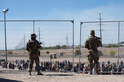 U.S. soldiers watch over a group of migrants waiting to be allowed by the U.S. authorities to go to a CBP processing center in El Paso, to process their immigration claim, after having crossed the US-Mexico border, as the United States prepares to lift COVID-19 era Title 42 restrictions that have blocked migrants at the U.S.-Mexico border from seeking asylum since 2020, near El Paso, Texas, U.S., May 10, 2023. Photo by Roberto Schmidt/REUTERS